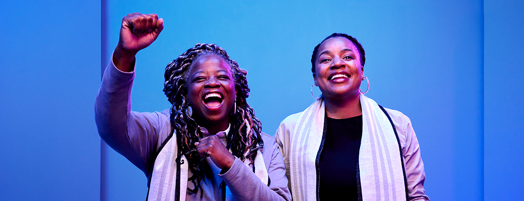 Image of two women in a different area and one of them is cheering